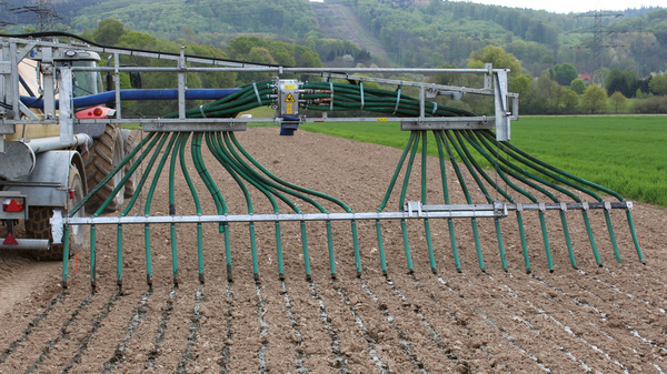 Auf einer landwirtschaftlichen Fläche wird mit einem Traktor und entsprechenden Geräten Stickstoff als Dünger ausgebracht und kann so als Nitrat ins Grundwasser gelangen.