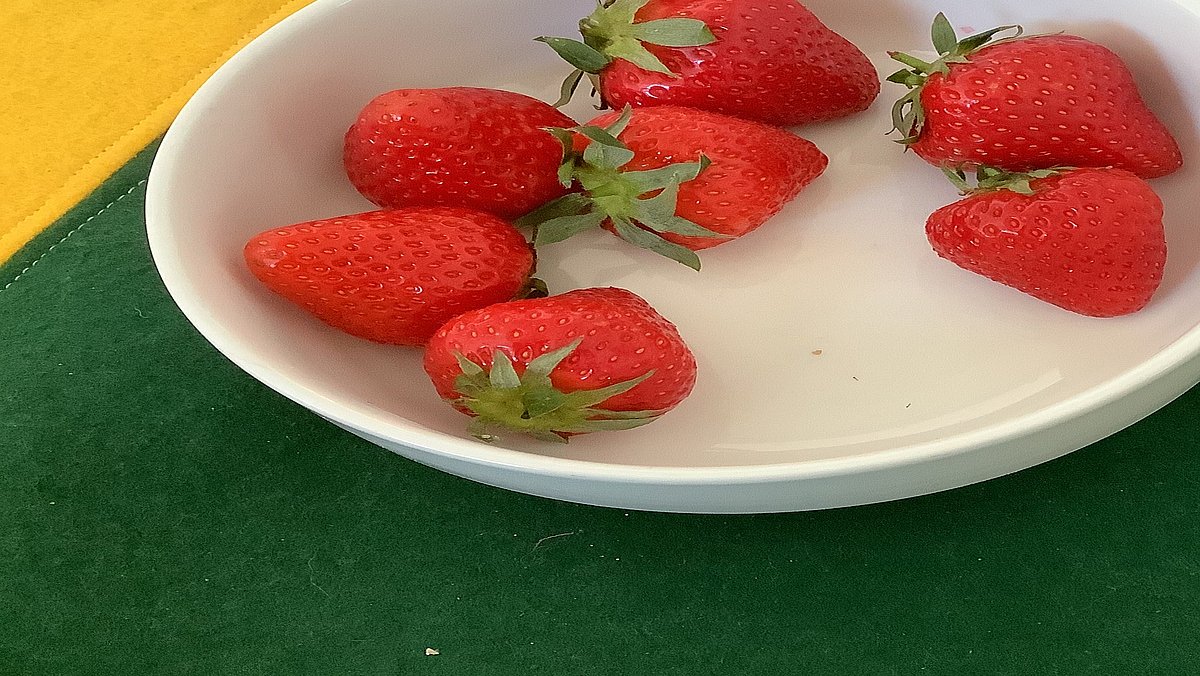 Wir besprechen, welches Obst regional und saisonal ist und welche Sorten per Flugzeug zu uns nach Deutschland transportiert werden. Danach lassen wir uns Erdbeeren schmecken.