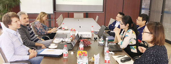 Mehrere Mitarbeitende der Firma Brugger Magnetsysteme sitzen in einem Besprechungsraum an einem Tisch vor einer Präsentation im Rahmen des Audits.