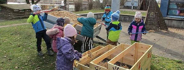 Gemeinsam wird das Hochbeet gefüllt. Erst mit Hackschnitzel und im Anschluss mit Erde.