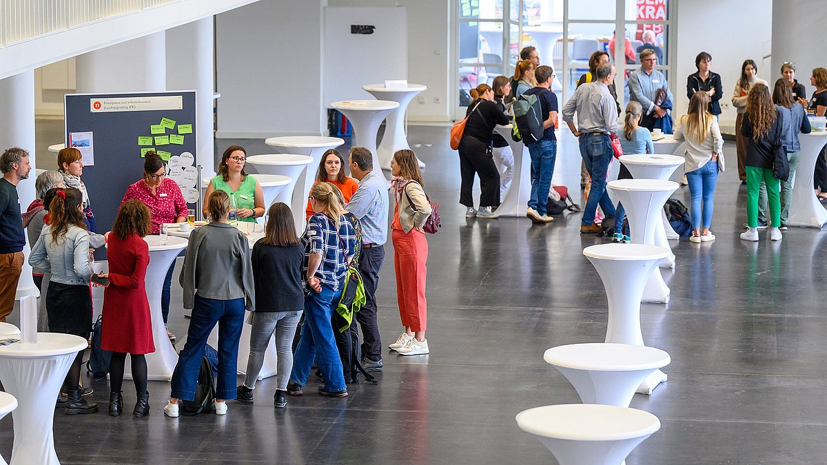 Eine Gruppe Menschen diskutiert an den Thementischen des BNE Netzwerkforums