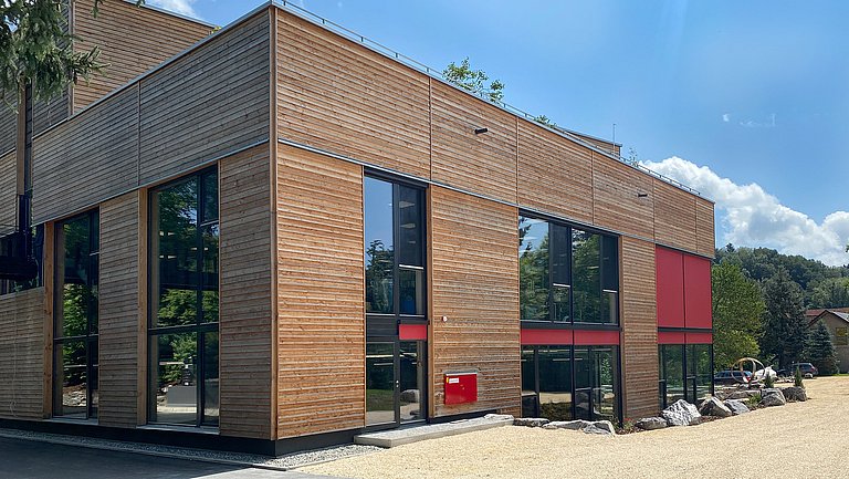 Ein Gebäude der Sonett GmbH mit großzügigen Fensterfronten und einer kompletten Holzfassade.