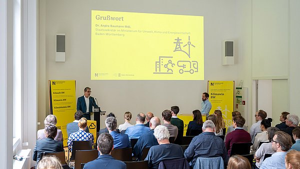 Grußwort von Staatssekretär André Baumann vor dem gesammelten Publikum