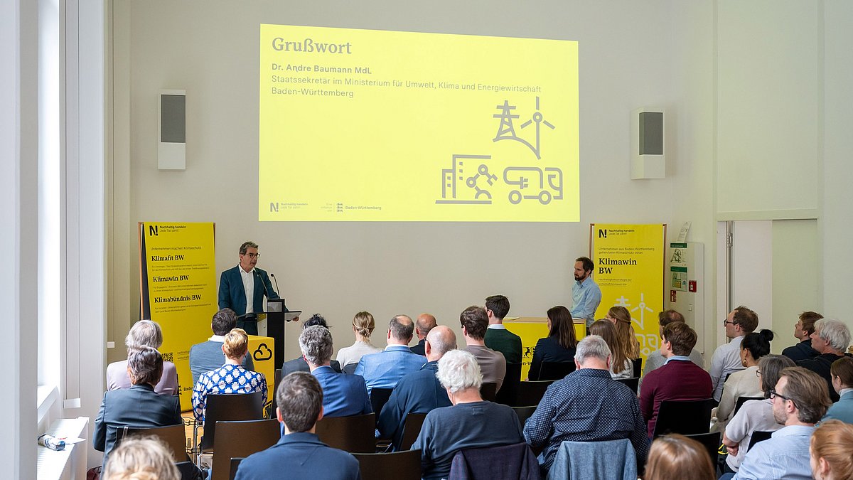 Grußwort von Staatssekretär André Baumann vor dem gesammelten Publikum