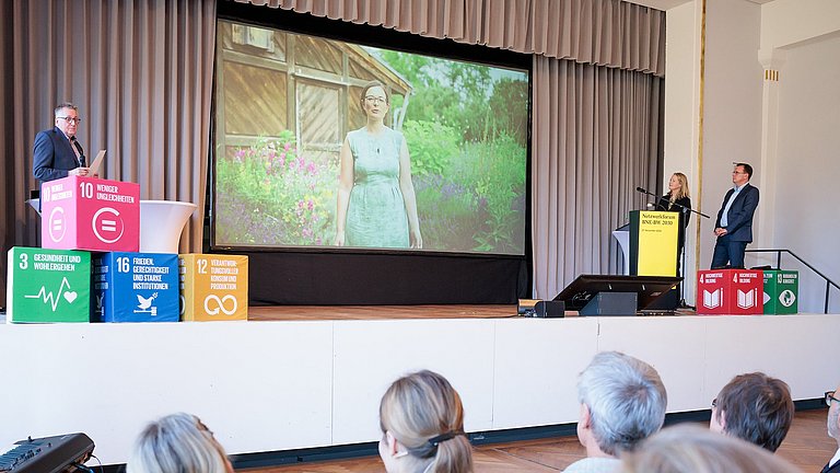 Filmpräsentation auf der Bühne bei der Veranstaltung Netzwerkforum BNE-BW 2023 im Herbst 2024.