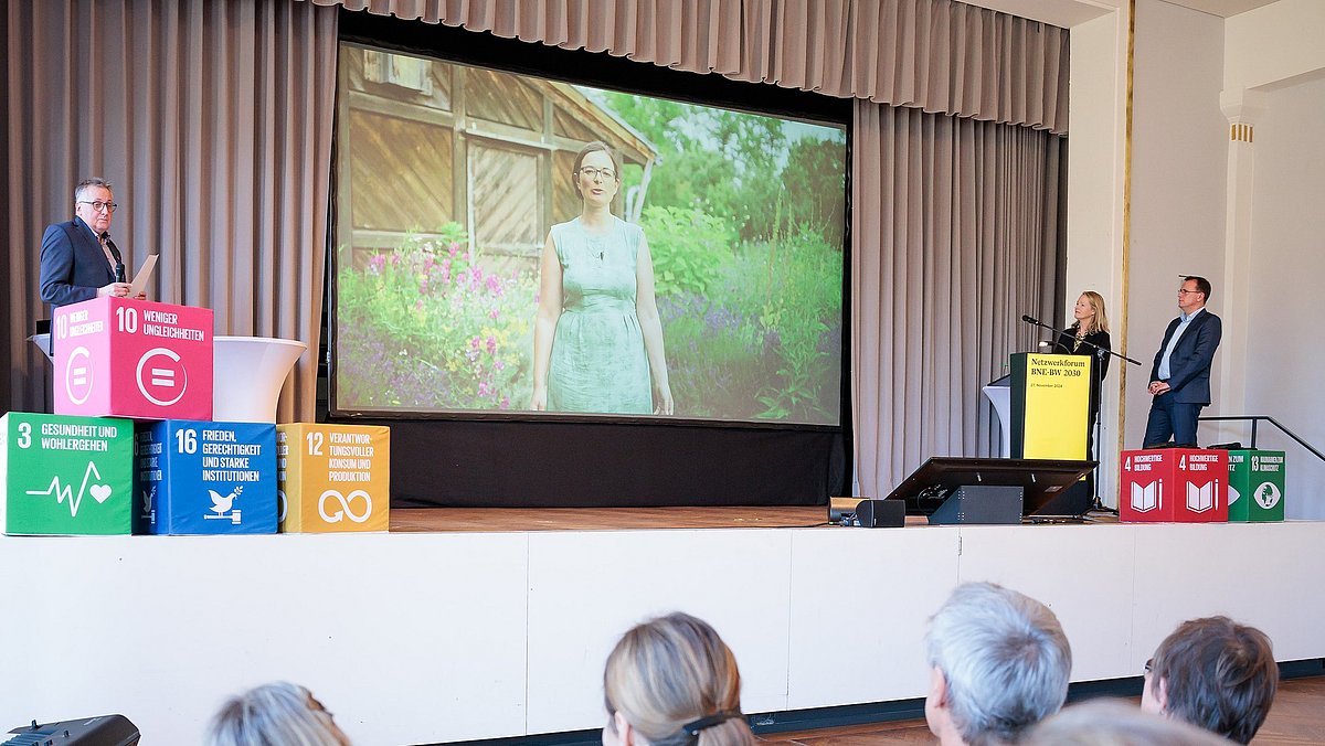 Filmpräsentation auf der Bühne bei der Veranstaltung Netzwerkforum BNE-BW 2023 im Herbst 2024.