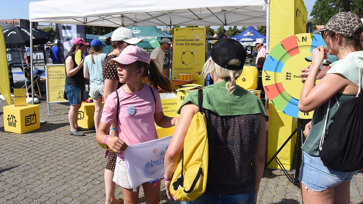 Viele Menschen am Stand der N!-Charta Sport mit Glücksrad