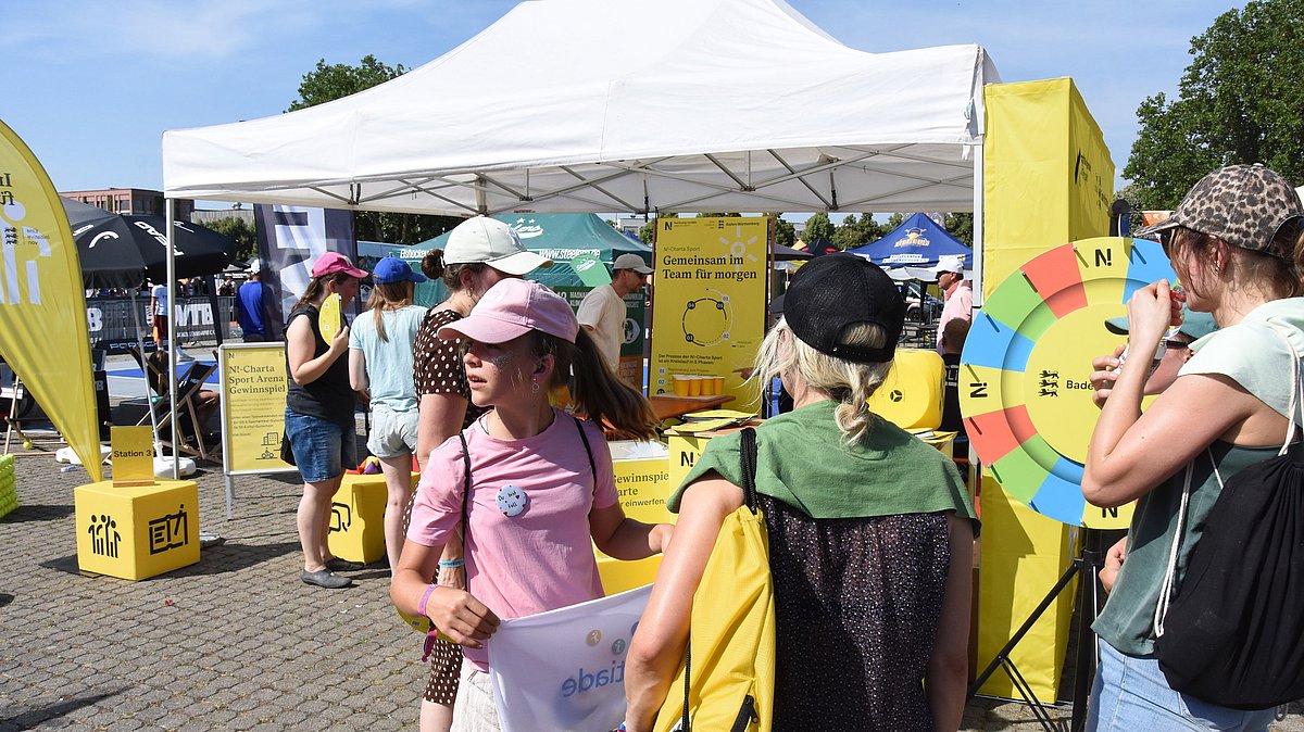 Viele Menschen am Stand der N!-Charta Sport mit Glücksrad