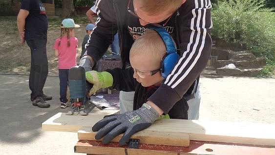 Die Eltern bauen an einer Nachmittagsaktion mit den Kindern zwei Komposte.