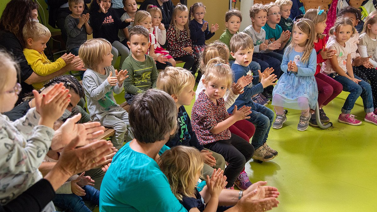 Eine Gruppe von Kindern im Kindergartenalter, die applaudieren
