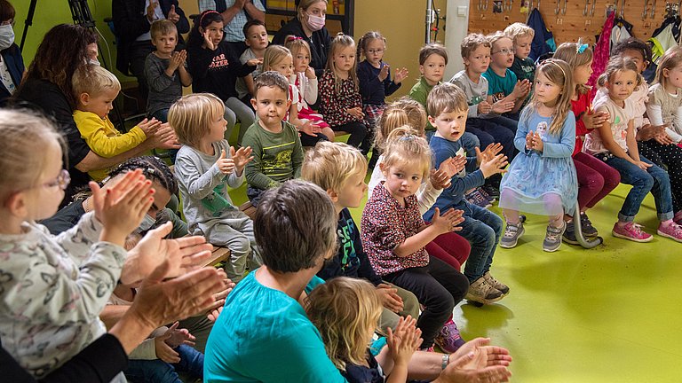 Eine Gruppe von Kindern im Kindergartenalter, die applaudieren