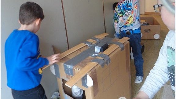 Die Kinder bauen und spielen mit Abfallmaterial.