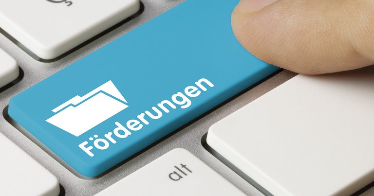 Tastatur mit einer Taste "Förderungen" und einem Finger, der auf diese Taste drückt.