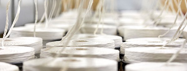 Bei der Produktion von Baumwollgarnen werden diese auf Spindeln aufgerollt.