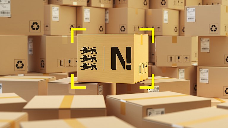 Viele Versandpakete sind übereinandergestapelt. In der Mitte steht ein Paket mit dem Logo der Nachhaltigkeitsstrategie Baden-Württemberg.