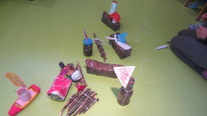 Bastelmaterialien, die ein kleines Schiff ergeben sollen.