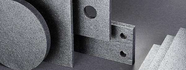 Verschiedene Kunststoffplatten in Grautönen sind über- und hintereinander platziert.