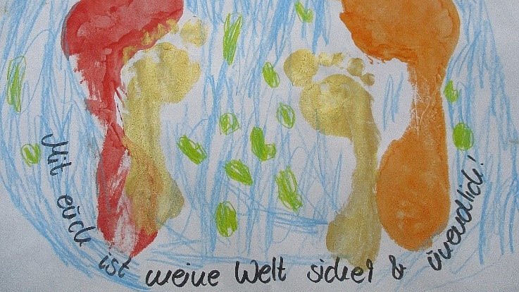 Kinder und ihre Eltern gestalteten ein Gemeinschaftsbild mit den Fußabdrücken der Kinder und der Eltern.