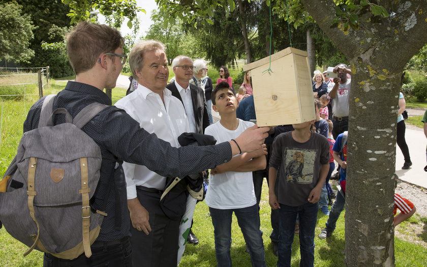 Umweltminister Untersteller und Kinder begutachten selbst gebaute Nistkästen für Vögel