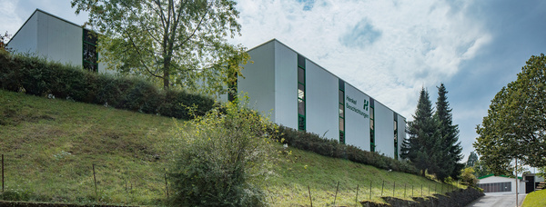Die Gebäude der Richard Henkel GmbH stehen auf einer grün bepflanzten Anhöhe.