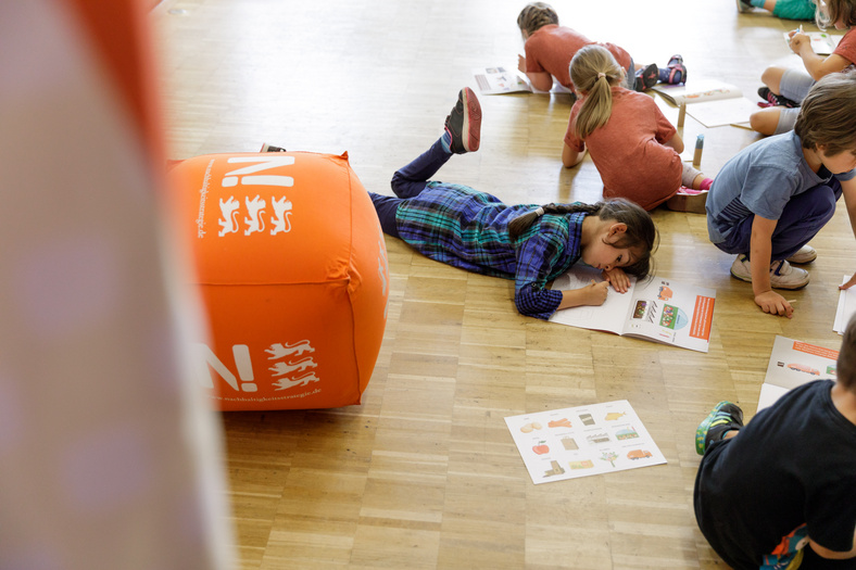 Kinder spielen mit dem Malbüchle Blubsi und Pupsi, die Bioabfall-Helden