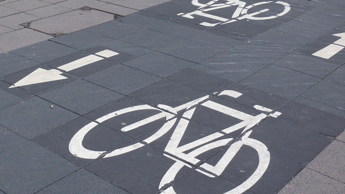 Ein sehr gut gekennzeichneter Fahrradweg weist am Boden die Richtungen aus.
