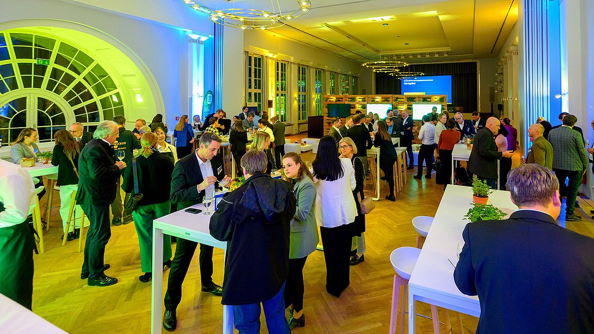 Viele Unternehmensvertreterinnen und -vertreter tauschen sich im Rahmen einer Veranstaltung zum Klimabündnis Baden-Württemberg intensiv aus.