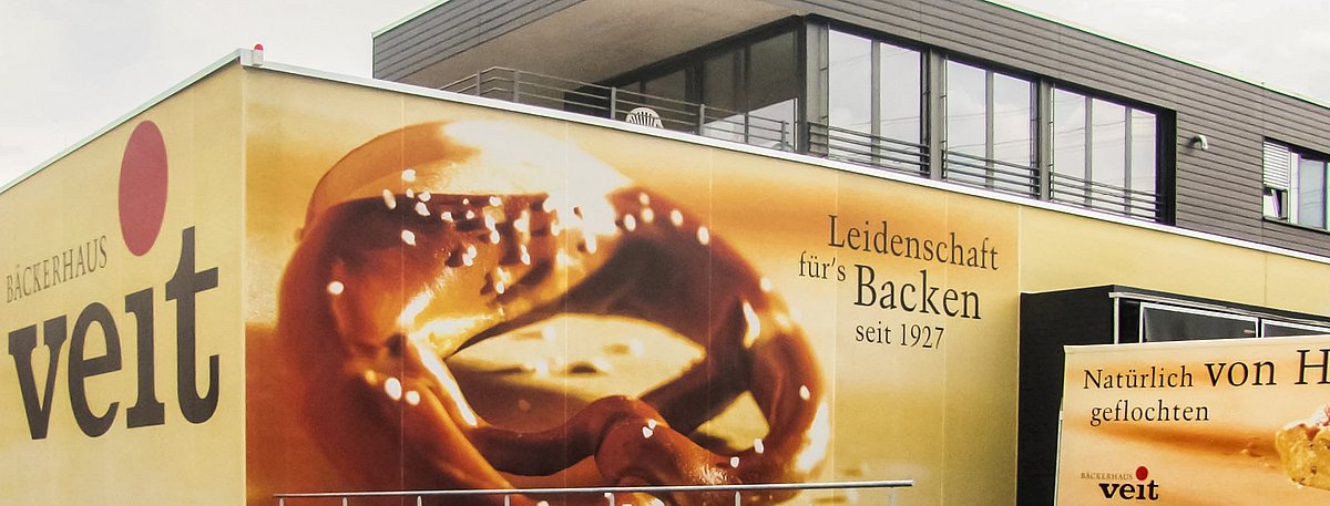 Das Backhaus der Bäckerei Veith von außen. Die Fassade ziert das Bild von einer großen Brezel und dem Schriftzug von Veith.
