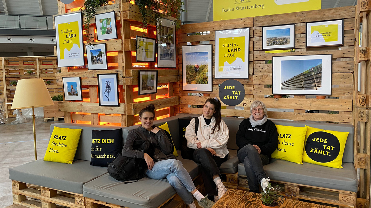 Drei Personen sitze in der Klimaländlounge der Nachhaltigkeitsstrategie Baden-Württemberg auf der Messe FairHandeln
