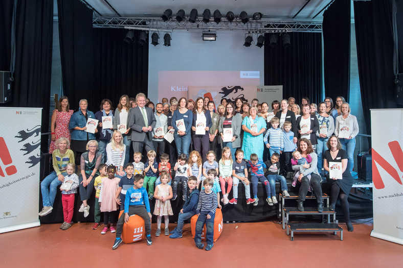 Herr Minister Franz Untersteller posiert für ein großes Gruppenfoto mit Kindern und allen Teilnehmenden des Workshops