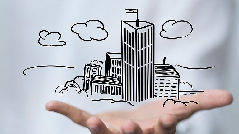 Über einer Handfläche schwebt unterschiedliche gezeichnete Häuser.