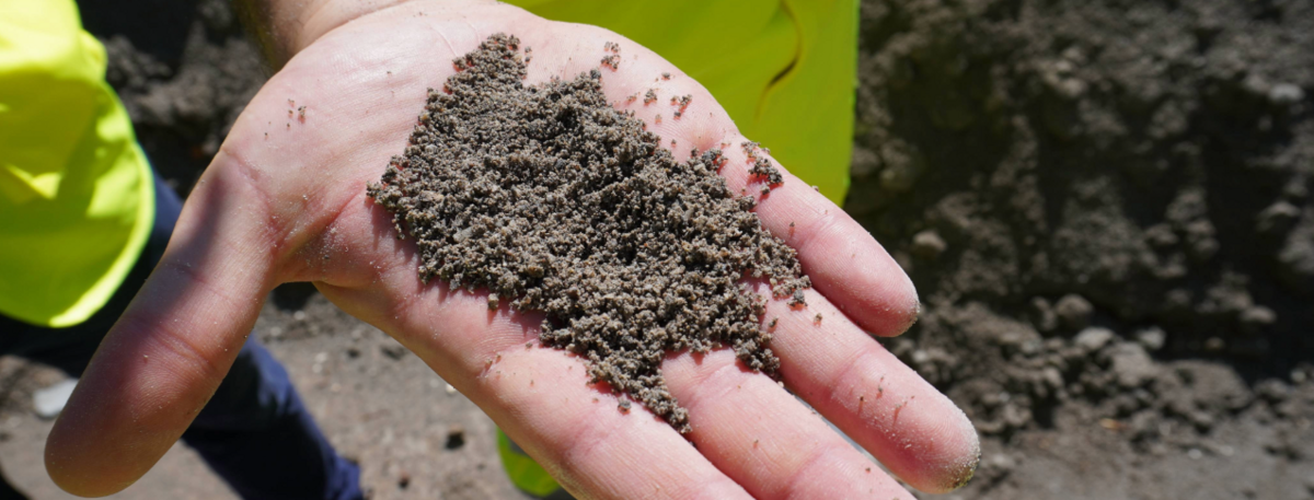 Brechsand auf einer Hand nach Aufbereitung aus Abbruchbeton 