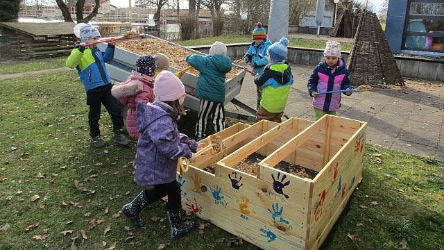 Gemeinsam wird das Hochbeet gefüllt. Erst mit Hackschnitzel und im Anschluss mit Erde.