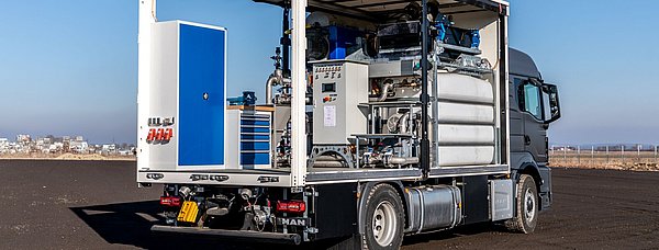 Ein MAN LKW mit einem Planenaufbau enthält Komponenten für Bohrschlammrecycling.