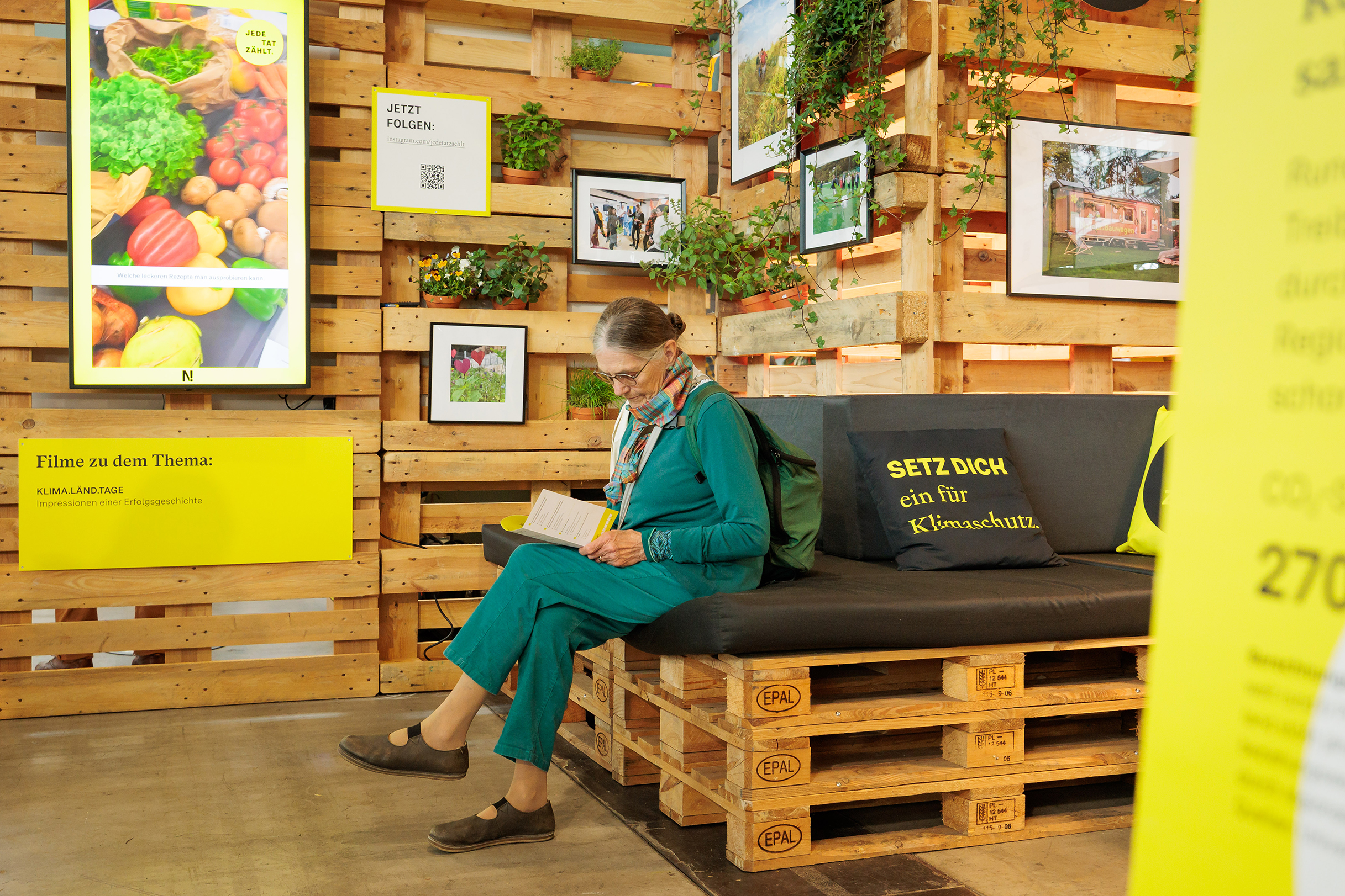 Eine Frau sitzt in aller Ruhe in der KLIMA.LÄND.LOUNGE bei der Messe Fair Handeln.