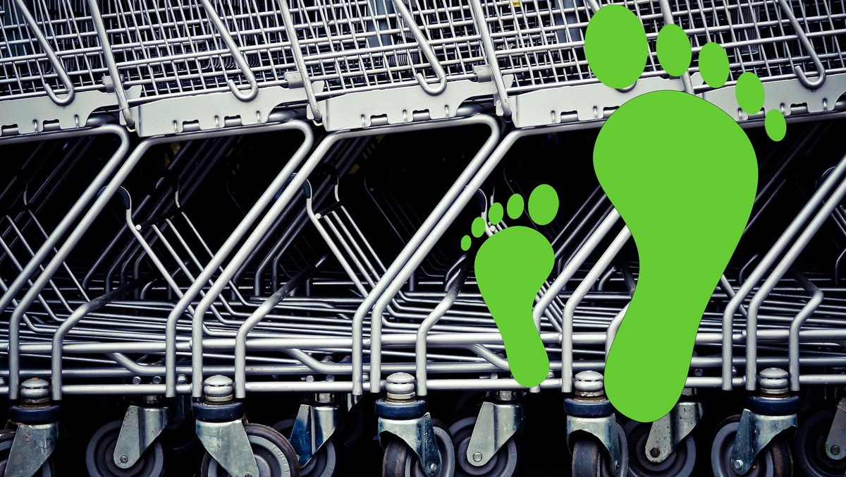 2 unterschiedlich große, grüne Fussabdrücke vor einer reihe Einkaufswägen