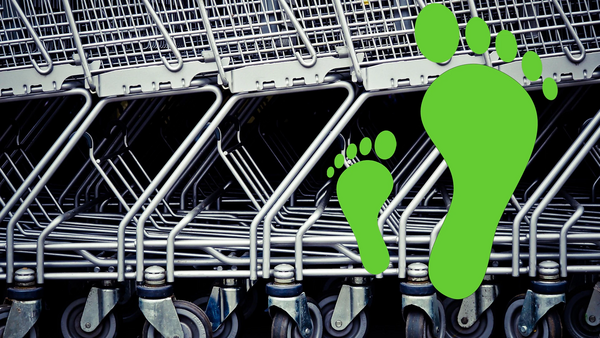 2 unterschiedlich große, grüne Fussabdrücke vor einer reihe Einkaufswägen