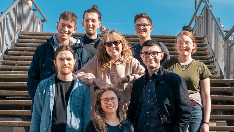 Jugendrats Wochenende 2024 Gruppenfoto Gemischte Gruppe junger Menschen aus dem Jugendrat stehen auf einer Treppe und lachen