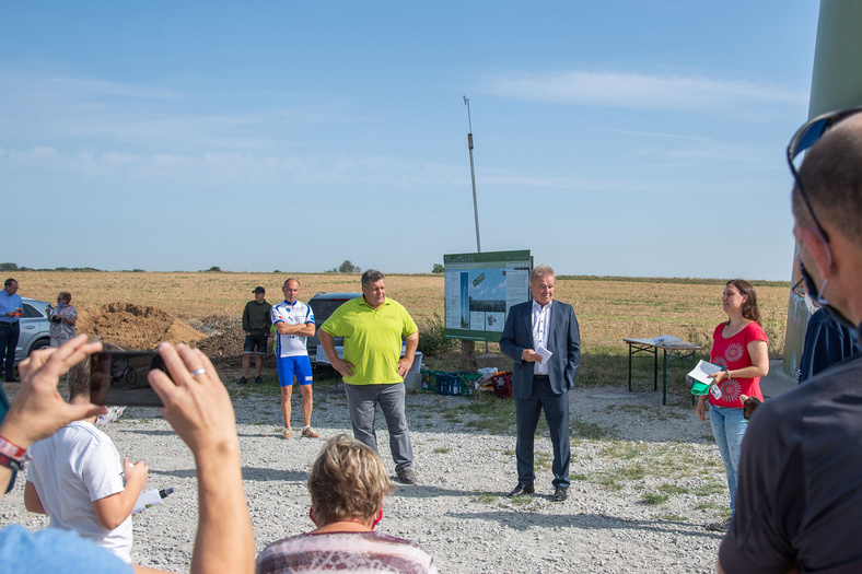 Eine gruppe von Menschen und Minister Untersteller haben sich vor dem Windkraftwerk in Ingersheimm versammelt.