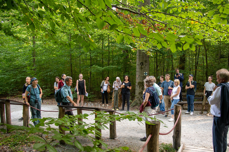 Eine Gruppe von Menschen und Minister Untersteller stehen im Wald. 
